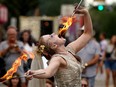 Tara Lambert (The Undead Newlyweds) eats some fire while performing on the street at the 2022 Edmonton International Fringe Theatre Festival in Edmonton on Tuesday August 16, 2022.