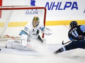 Team Bauer Jill Saulnier, right, shoots wide of Team Sonnet goalie Shea Tiley during third period PWHPA Dream Tour hockey action in Calgary, Alta., Monday, May 24, 2021.Women's professional hockey is expanding in North America, but remains divided.