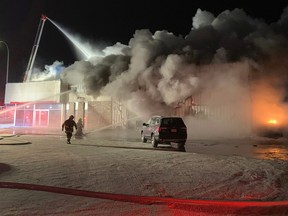 Fire crews battle a Dec. 30, 2019, blaze at a Honda dealership in Edson. The blaze was one of five alleged arsons to occur in western Alberta towns in late 2019/early 2020. The man accused in the arsons, Thomas Berube, began a trial on the charges on Aug. 22, 2022.