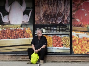 A man waits for a bus outside Capital Groceries & Halal Meat, 10806 107 Avenue, in Edmonton on Wednesday August 3, 2022.