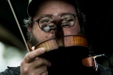 De Temps Antan's David Boulanger sings into the microphone on his violin at the Edmonton Folk Music Festival, Saturday Aug. 6, 2022.