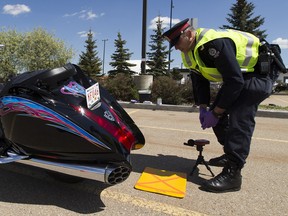 Const. Trevor Henderson of the Edmonton Police Service's traffic section tests the noise level of a motorcycle on May 28, 2020 in Edmonton.