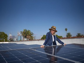 In this image provided by Ben Gibbs, Wendy Schmidt visits a community solar installation atop the roof of an Esperanza Community Housing apartment building, across the street from an oil drilling site in South Central Los Angeles on Nov. 3, 2021. The Schmidt Family Foundation funded the installation of the solar panels in 2017 so tenants could directly access renewable energy.