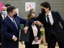 Prime Minister Justin Trudeau and Alberta Premier Jason Kenney, left, bump elbows during a joint federal-provincial announcement of $10-a-day daycare at Boyle Street Plaza in Edmonton on Nov. 15, 2021.