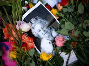 A photograph of Queen Elizabeth II lays among the flowers at a memorial site in Green Park near Buckingham Palace following the death of the queen on Sept. 11, 2022 in London, U.K. Alberta is mulling making Monday a public holiday for the Queen's funeral.