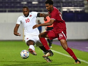 Canada's forward David Hoilett (L) and Qatar's defender Homam Ahmed vie for the ball during the friendly football match between Qatar and Canada in Vienna on September 23, 2022.
