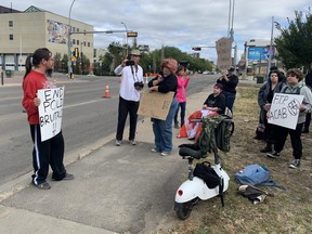 Community members hold a protest outside Edmonton Police headquarters on Sunday, Sept. 18, 2022. The group is calling for the release of CCTV footage of an officer shoving a woman to the ground during a recent arrest.