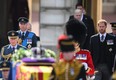 King Charles III, Prince William, Prince of Wales and Prince Harry, Duke of Sussex walk behind the gun carriage bearing the coffin of the late Queen Elizabeth II as it departs Buckingham Palace, transferring the coffin to The Palace of Westminster, in London, Wednesday, Sept. 14, 2022.