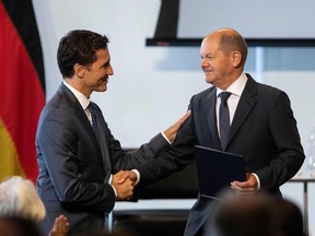 Canada's Prime Minister Justin Trudeau, left, shakes hands with German Chancellor Olaf Scholz during the Canadian-German Business Forum in Toronto, Ontario, Canada, on August 23, 2022. - In his three-day visit, Scholz said Germany is rushing construction of liquid natural gas ports infrastructure and pipelines to boost imports and is reaching out to other nations, like Canada, to increase their output. (Photo by Cole Burston / AFP)