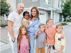 Vanessa van Tol and her husband Jordan pose for a photo with their children Malaya, 6, baby Reamohetse, Maverick, 8, Cruz, 10, and Roan, 8, in this undated handout photo. With a family of seven living in a three-bedroom townhouse and a fitness business she runs from home, Vanessa van Tol is a pro at maximizing space.