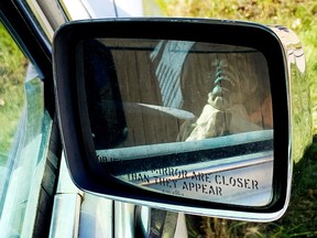 A ghoulish character is reflected in the side mirror of a decommissioned hearse parked along a residential street in Edmonton's Tamarack neighbourhood, Tuesday Sept. 6, 2022. The vehicle was being used to advertise the Monster Mini Golf business.