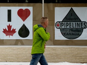 A pedestrian walks past pro-Canadian oil signs in the window of the O'Canada Gear Store at 9859 76 Ave. in Edmonton on Tuesday, December 31, 2019 David Bloom