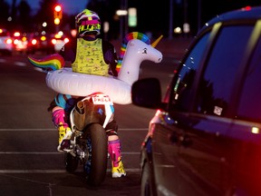 A motorcyclist wears an inflatable unicorn while making their way along 111 Street near Whitemud Drive, in Edmonton Friday, Sept. 2, 2022. Photo By David Bloom