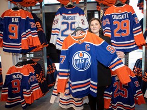 Carla Lloyd, director of retail at Oilers Entertainment Group, holds the new Edmonton Oilers retro team jersey as it is
revealed at the team store in the ICE district on Wednesday, Sept. 21, 2022.