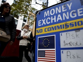 People walk past a currency exchange bureau in London, Monday, Sept. 26, 2022. The pound today slumped to its lowest level against the dollar since 1971, after the Chancellor hinted more tax cuts would follow those he announced last week. The pound dipped as low as $1.0349 per U.S. dollar early Monday but then rebounded to $1.0671, down 2.3%.
