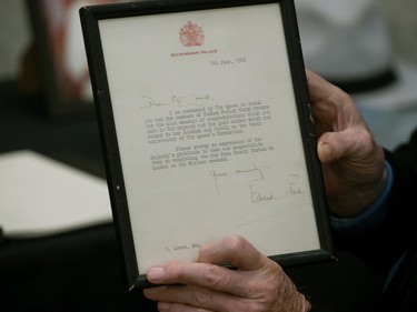 Brian Lowes displays a message he received from the Queen as he signs a book of condolence for Queen Elizabeth II at the Alberta Legislature in Edmonton, Friday, Sept. 9, 2022.