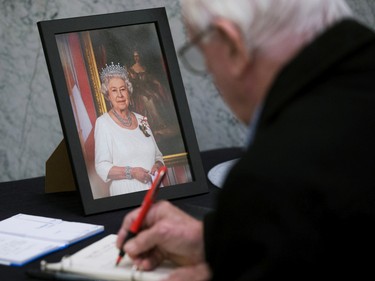 Brian Lowes signs a book of condolence for Queen Elizabeth II at the Alberta Legislature in Edmonton, Friday, Sept. 9, 2022.