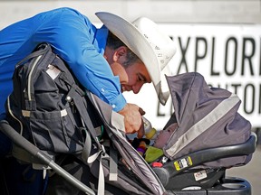 Rodeo cowboy Morgan Grant feeds his 10-week-old son Jackson outside the Edmonton Expo Centre on Wednesday Sept. 14, 2022, where it was announced that the Edmonton Pro Rodeo will be held at the Edmonton Expo Centre on Sept. 23-24.