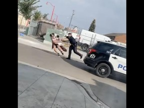 Screenshot of a video depicting an Edmonton police officer seen shoving a woman to the ground during an arrest on Thursday, Sept. 15, 2022 in the area of 106 Avenue and 101 Street.