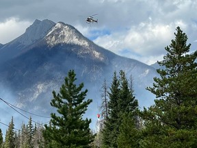 A helicopter dumps water over the Chetamon Mountain blaze in Jasper National Park on Saturday, Sept. 10, 2022. (Supplied photo/Parks Canada)