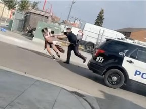 Screenshot of a video depicting an Edmonton police officer seen shoving a woman to the ground during an arrest on Thursday, Sept. 15, 2022, in the area of 106 Avenue and 101 Street.