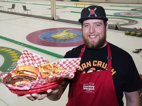 Travis Meyer, kitchen manager/chef at Flat Boy Burgers, with a smashburger and fries at the Granite Curling Club in Edmonton, where the eatery now operates  from six days a week, opening at 12 p.m.