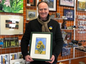 Poet David Brydges holds Laura Landers' painting used for the cover of the Poets for Ukraine anthology — including work from members of the Stroll of Poets and The Parkland Poets.