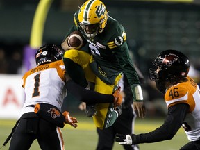The Edmonton Elks quarterback Tre Ford (2) is tackled by the B.C. Lions' Garry Peters (1) at Commonwealth Stadium in Edmonton on Friday, Oct. 21, 2022.