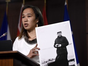 NDP MP Mumilaaq Qaqqaq holds a photo of Johannes Rivoire, a priest who is wanted in Canada but resides in France, during a news conference on Parliament Hill in Ottawa, July 8, 2021. The federal government says France has denied an extradition request for the priest.Justin Tang