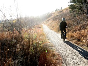 A person rides an electric unicycle along a trail in Edmonton's Rundle Park, Thursday, Oct. 27, 2022.