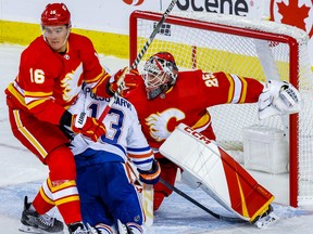 Calgary Flames Nikita Zadorov battles against Jesse Puljujarvi of the Edmonton Oilers in front of goalie Jacob Markstrom during NHL hockey at the Scotiabank Saddledome in Calgary on Saturday, October 29, 2022. AL CHAREST/POSTMEDIA
