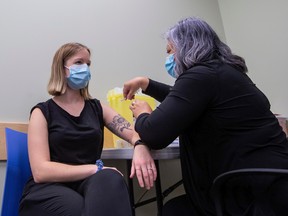 Sarah Peterson gets the flu vaccine from Registered Nurse Anna McGillivray as Alberta's influenza immunization campaign begins on Monday, Oct. 17, 2022 in Edmonton, to all Albertans six months of age and older. COVID-19 vaccines, including boosters, may also be offered to individuals that are eligible with each influenza vaccine appointment booked.