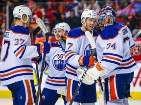 Edmonton Oilers goaltender Stuart Skinner (74) and center Connor McDavid (97) celebrate win with teammates against the Calgary Flames at Scotiabank Saddledome.