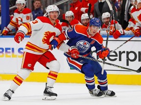 Edmonton Oilers forward Ryan Nugent-Hopkins (93) and Calgary Flames forward Tyler Toffoli (73) chase a loose puck during the third period at Rogers Place on Oct. 15, 2022.