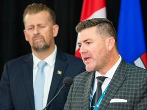 Mike Ellis, associate minister of mental health and addictions, left, listens to Dr. Robert Tanguay, co-chair, Alberta Pain Strategy and co-lead, Rapid Access Addiction Medicine Program, Alberta Health Services. The two were speaking at a news conference to announce new rules for the use of high-potency opioids on Oct. 5, 2022.