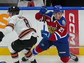 Edmonton Oil Kings Rhett Melnyk (right) evades a check by Calgary Hitmen Grayden Siepmann during WHL hockey action in Edmonton on Friday October 28, 2022.