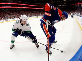 The Edmonton Oilers' Leon Draisaitl (29) battles the Vancouver Canucks' Quinn Hughes (43) during first period NHL action at Rogers Place in Edmonton, Wednesday Oct. 102, 2022.