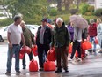 People line up with jerry cans to buy gasoline after post-tropical storm Fiona, in Charlottetown, Monday, Sept. 26, 2022. Generators are an increasing necessity and nuisance as Atlantic Canada experiences more frequent and severe storms with extended power outages.