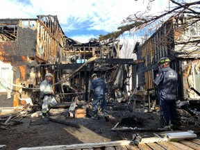 Fire investigators comb through the charred remains after a blaze at Summerhill Meadows, 4020 21 St., on Sunday, Oct. 30, 2022.
