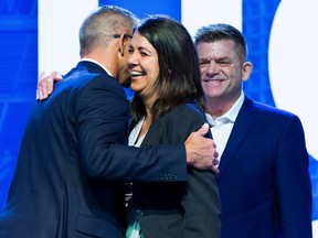 Travis Toews hugs Danielle Smith prior to her speech as Brian Jean watches at UCP annual general meeting on Saturday, Oct. 22, 2022 at the River Cree Resort and Casino.