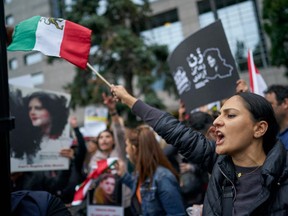 A woman waves an Iranian flag during a demonstration against the Iranian regime, in Toronto on Sept. 24, 2022.