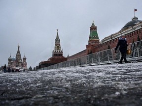 A pedestrian walks along the Spasskaya tower of the Kremlin at the Red Square in Moscow, on November 22, 2022.