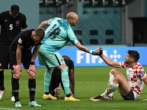 Canada's goalkeeper Milan Borjan helps a player of Croatia to stand up after being defeated by Croatia 4-1 in the Qatar.