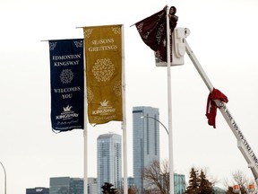 Crews with Discount Flags ltd. change a series of flags along Kingsway near Airport road, in Edmonton Tuesday, Nov. 22, 2022.