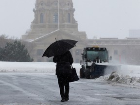 The Alberta legislature is visible in the background as Edmontonians make their way through the blowing snow on Wednesday, Nov. 2, 2022.