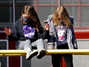 Children wear masks while playing during recess in a file photo from 2021.