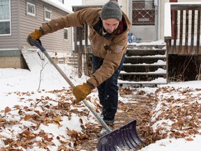 Andrew Cabinet shovels snow on 144 Street on Sunday, Nov. 6, 2022. The snow continues to fall along with the temperatures  in Edmonton.