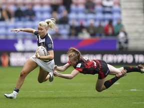 England's Tara-Jane Stanley, left, is tackled by Canada's Petra Woods, during the Women's Rugby League World Cup Group A match between England and Canada at the DW Stadium, in Wigan, England, Saturday, Nov. 5, 2022. The Canada Ravens look to finish their Rugby League World Cup campaign with a win against tournament debutant Brazil.