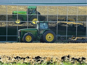 A tractor is reflected in the Agri-Food Discovery Place building windows while tilling a field at University of Alberta farm in Edmonton, 
file photo.