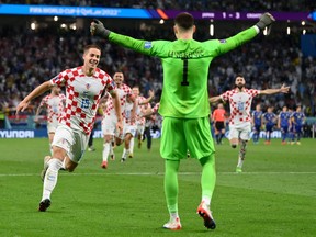 Croatia's Mario Pasalic (lef) and Dominik Livakovic celebrate after winning the penalty shootout against Japan.